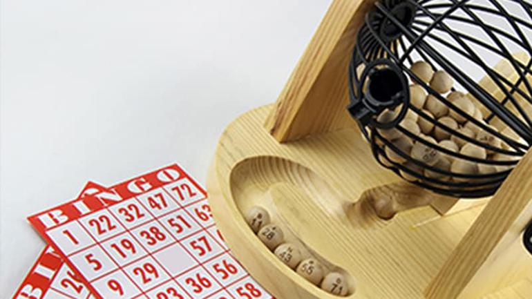 Globo para bingo com algumas bolinhas e cartelas de bingo, em uma atividade de festa junina