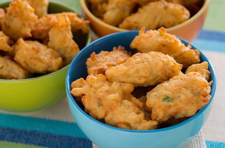 Porções de bolinhos de batata palha fritos servidos em tigelas coloridas como aperitivo
