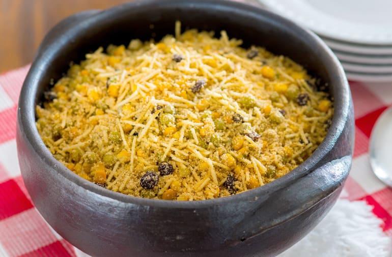 Farofa crocante com milho e batata palha, temperada com ervas, servida em panela de barro
