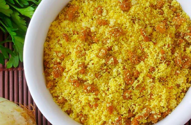 Salada de farofa de cenoura em tigela de porcelana, com cebola, azeitona, limão e salsinha