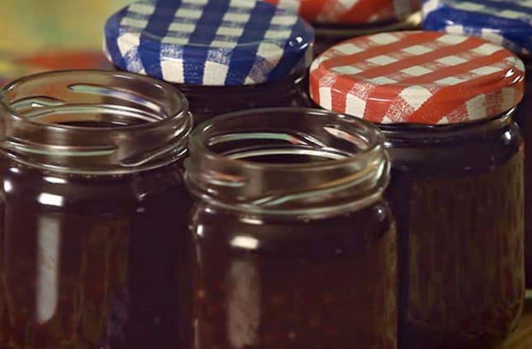 Sagu com vinho em potes de vidro com tampa xadrez, dispostos em decoração de festa junina