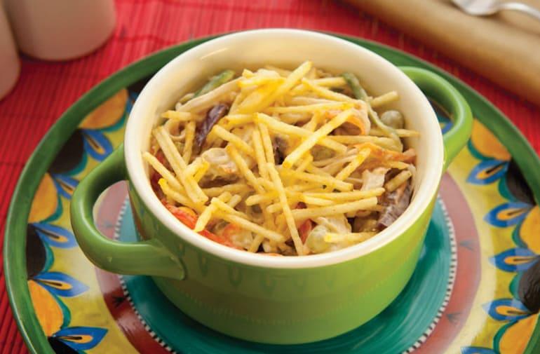 Salpicão de bacalhau servido em tigela verde e decorado com batata palha Yoki